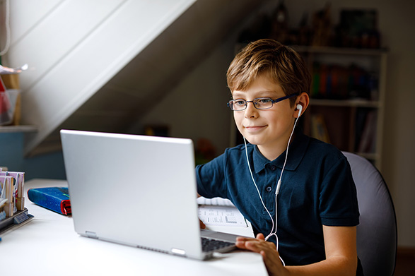 Schulkind am Laptop mit Brille