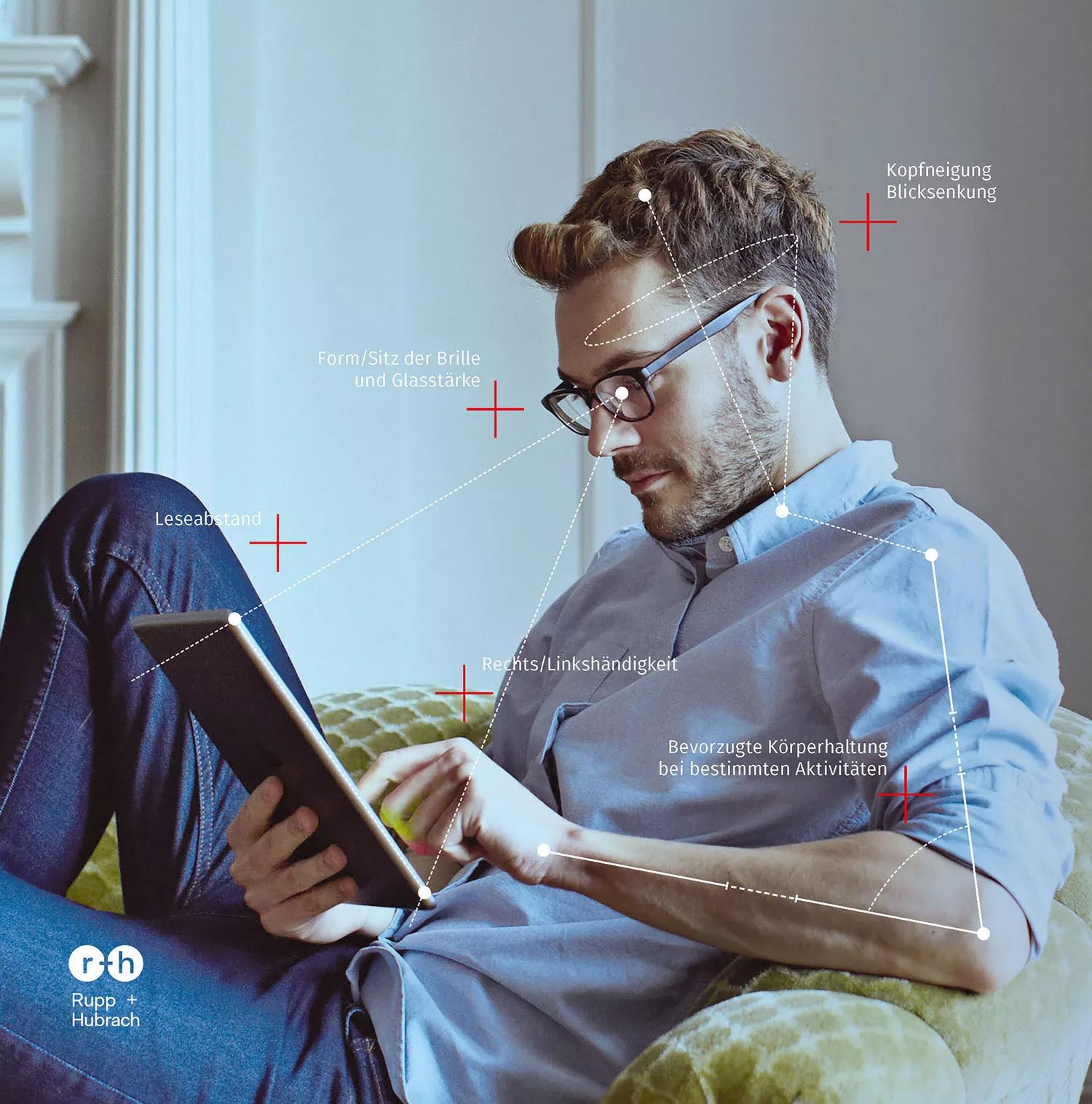Mann mit Brille liest am Tablet